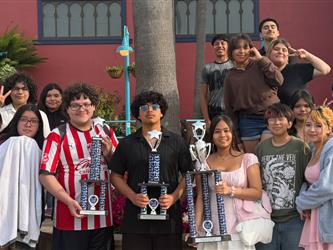 Mariachi team standing with trophy